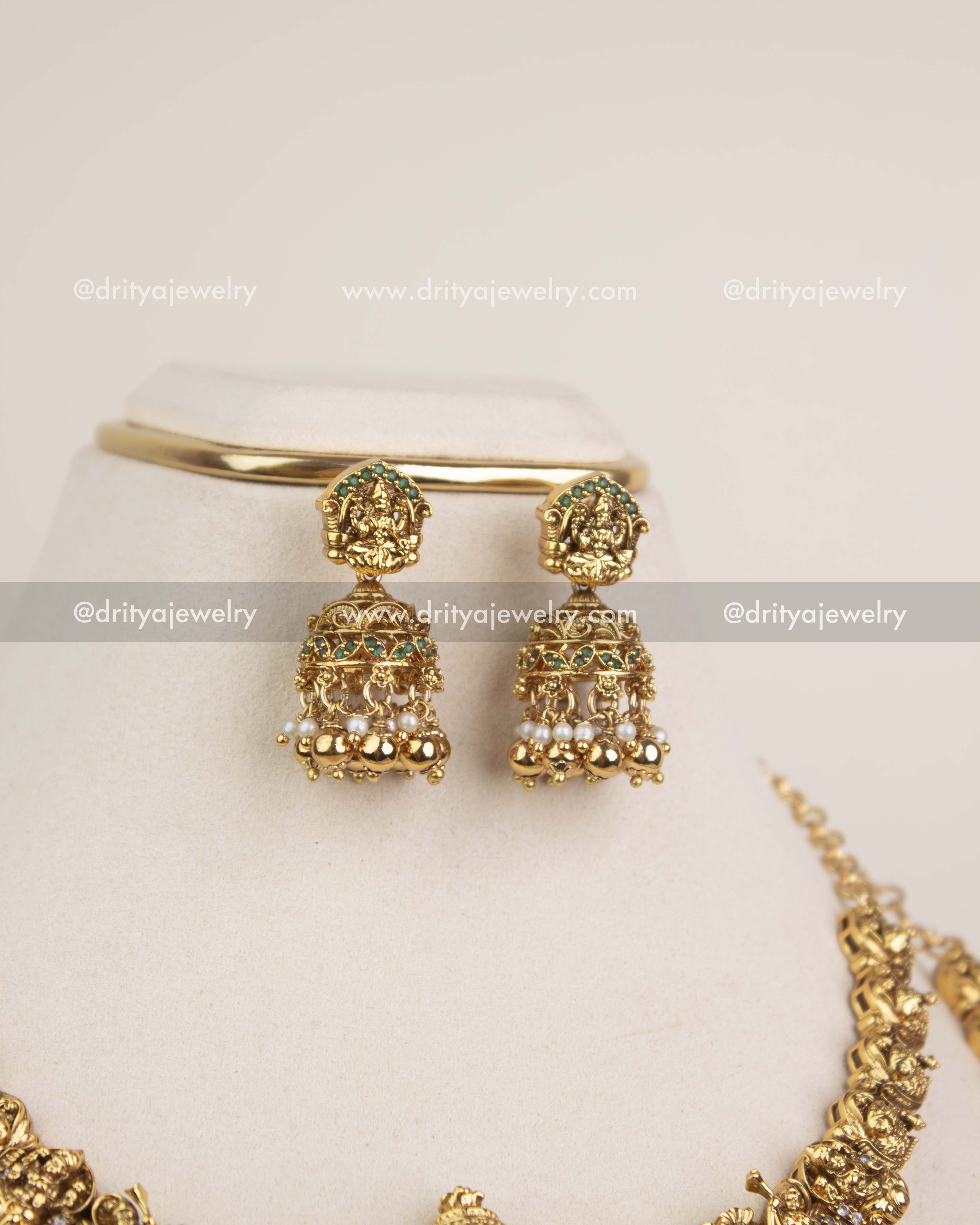 Antique gold temple jhumkas with Lakshmi studs and pearl embellishments