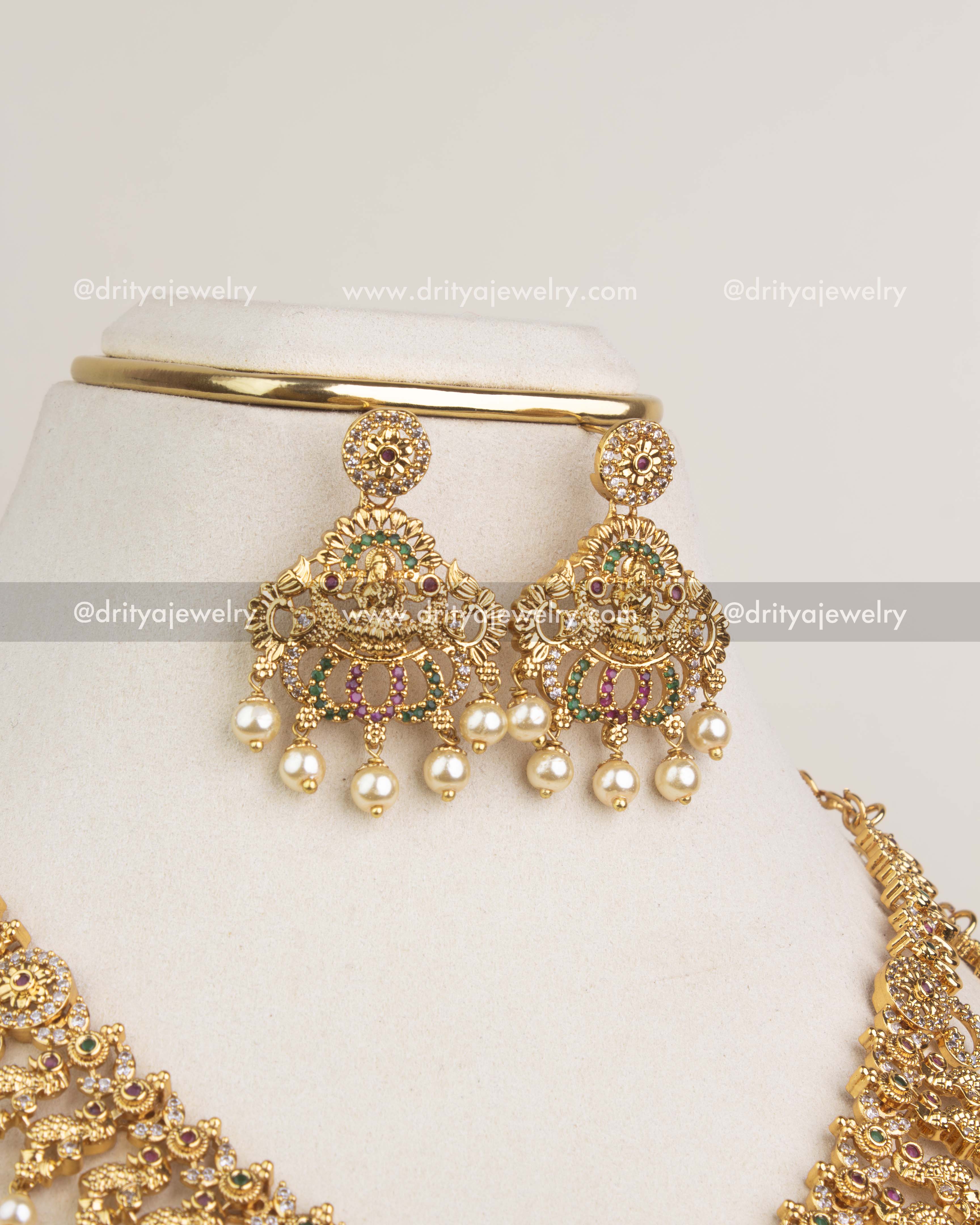 Gold-plated temple earrings with Lakshmi design and pearl clusters.
