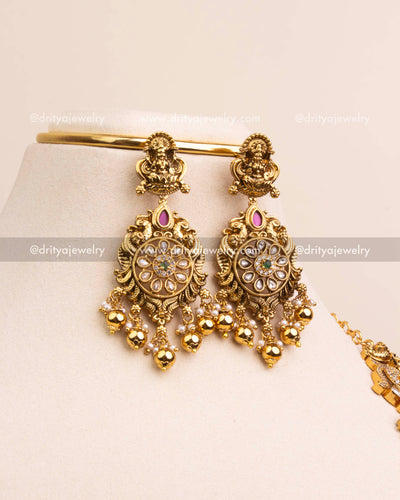 Pair of antique gold temple earrings with Kundan flower motifs and pearl drops