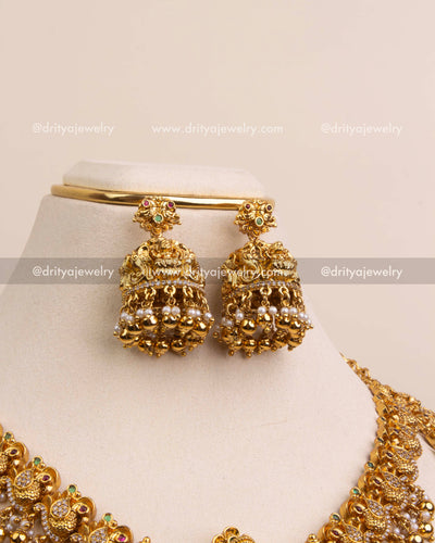 Traditional jhumkas with Lakshmi tops and clustered pearl bead finish.