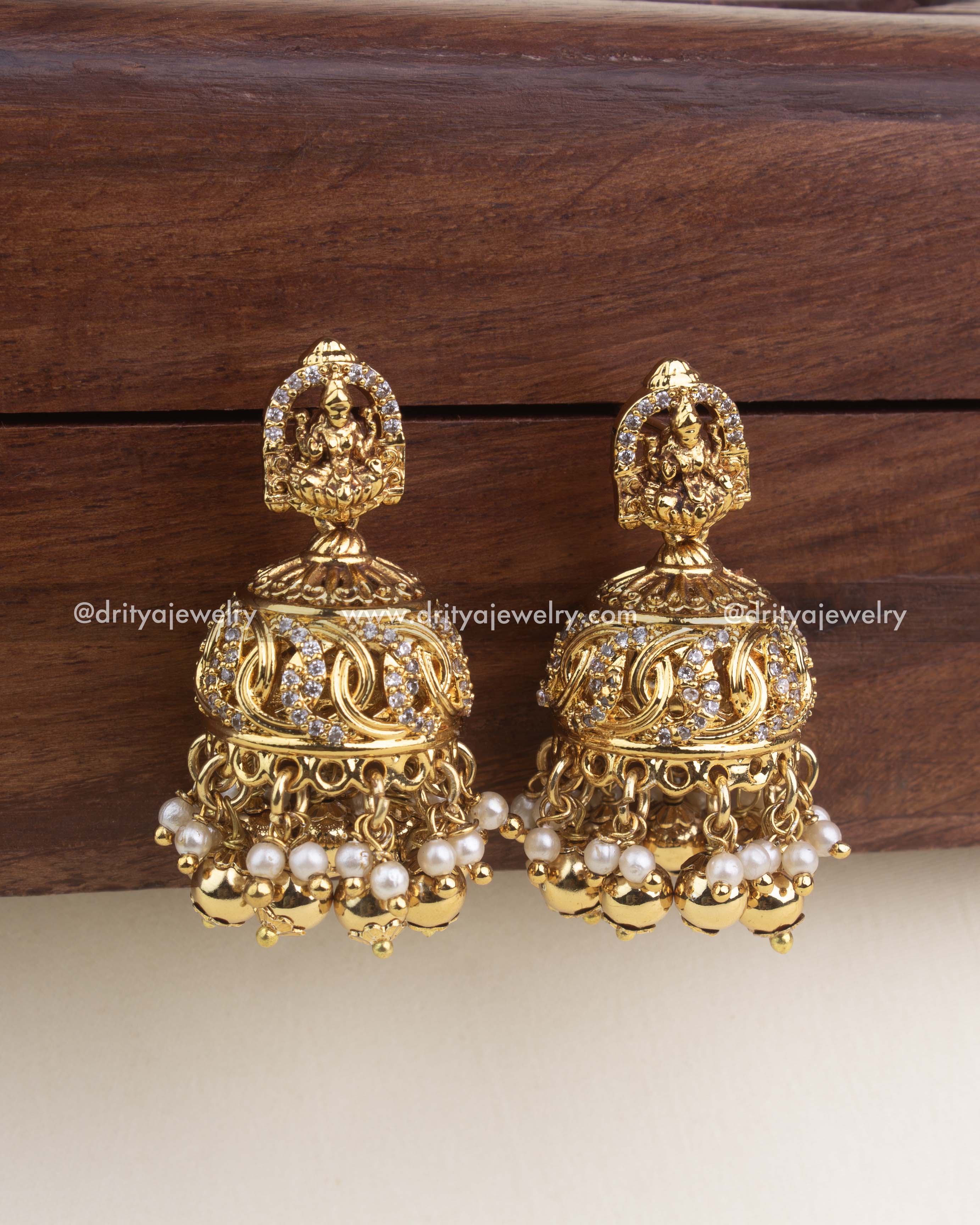 Nakshi temple jhumkas with CZ detailing and pearl-gold hangings.