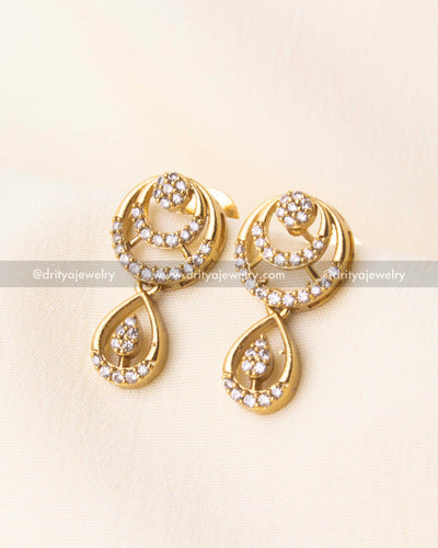 Matching CZ earrings with circular and tear-drop detailing in gold finish.