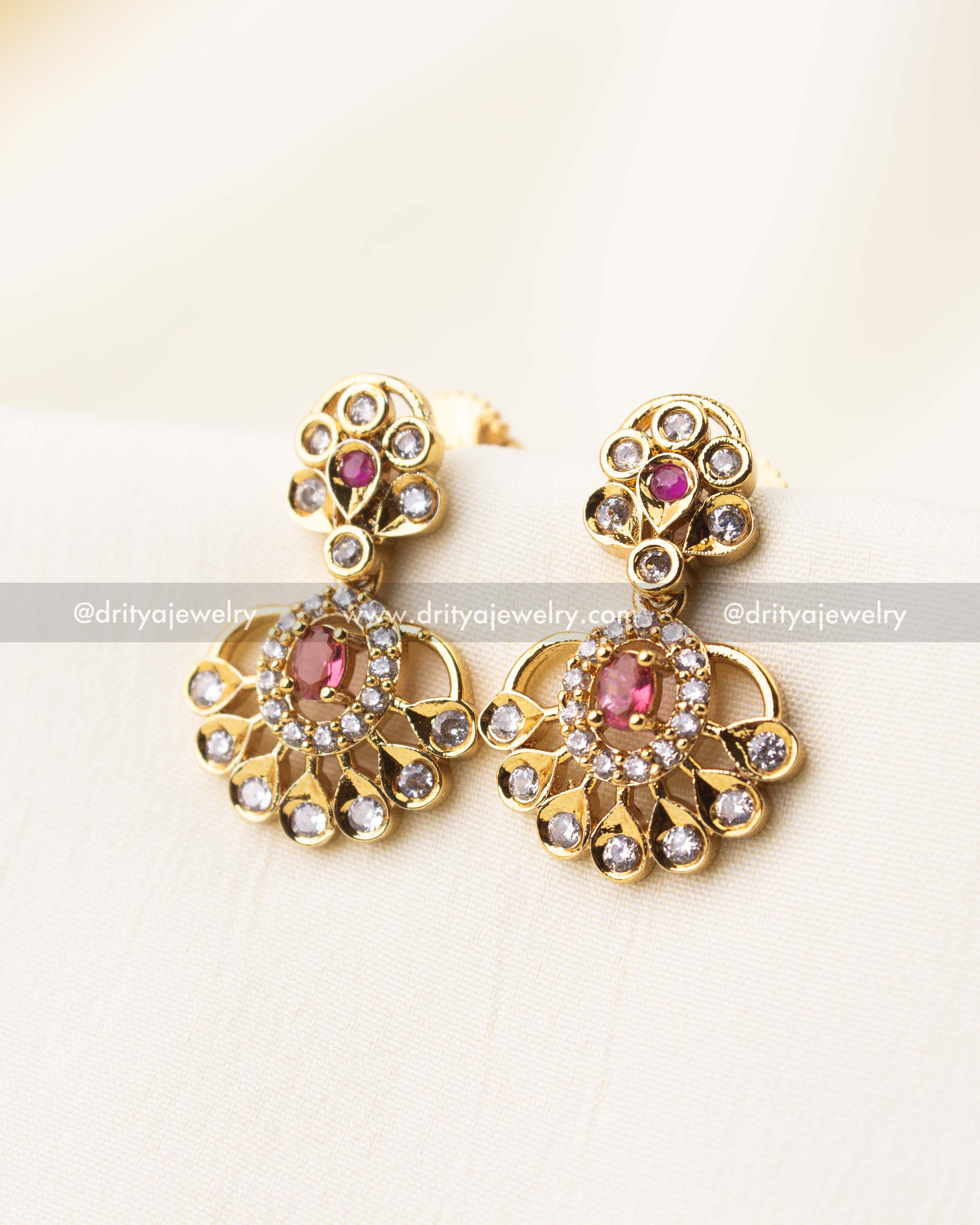 Pair of ruby red earrings with CZ petal design and gold finish