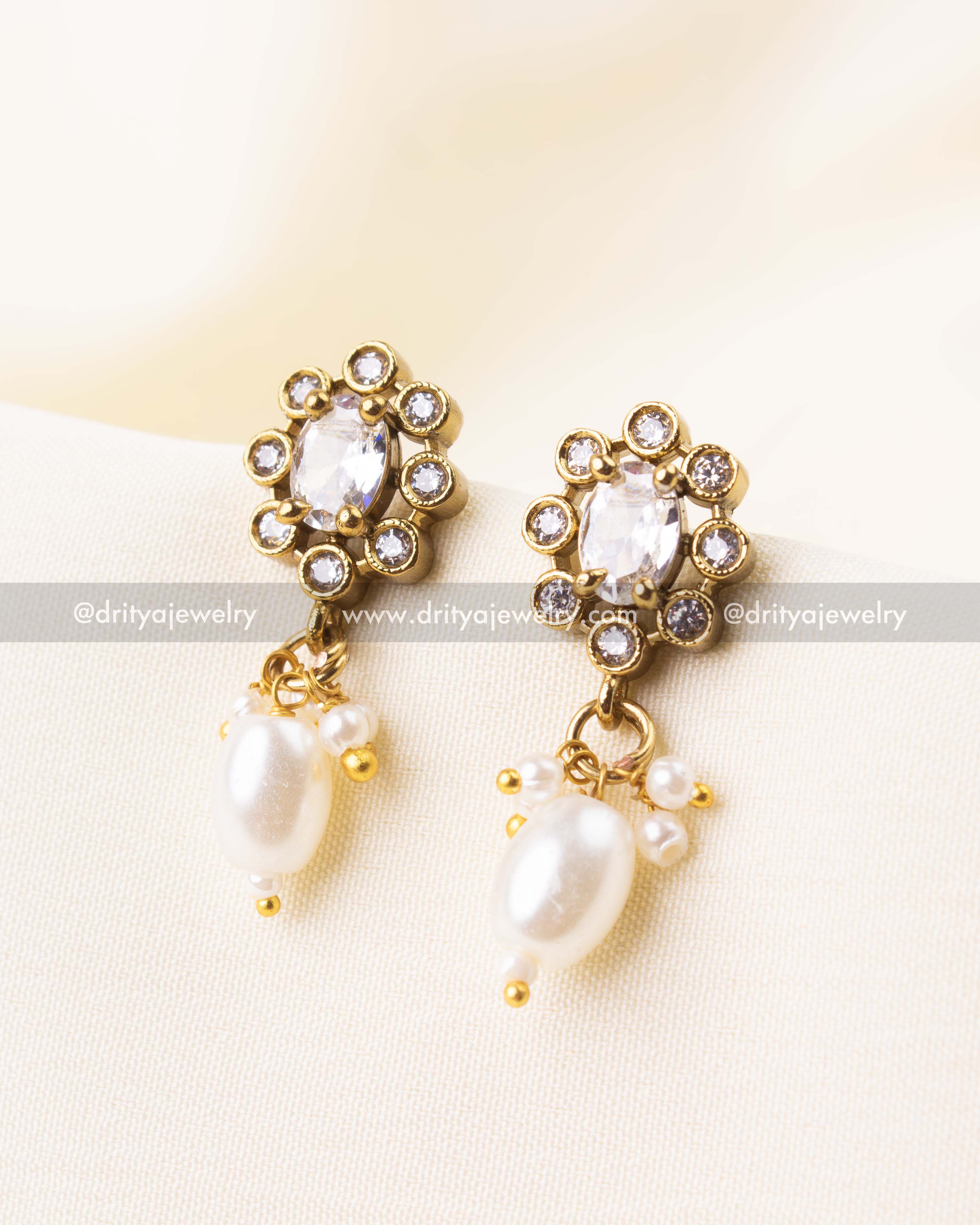 Stud earrings with white beads and CZ stone accents in gold finish.