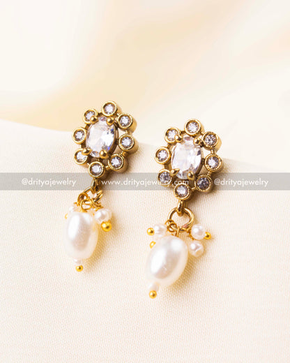 Stud earrings with white beads and CZ stone accents in gold finish.
