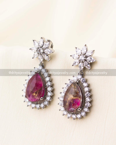 Teardrop earrings with deep pink stones and crystal-studded floral tops.
