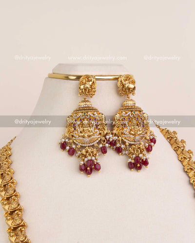 Lakshmi motif danglers with ruby red stone drops and temple-style detailing.