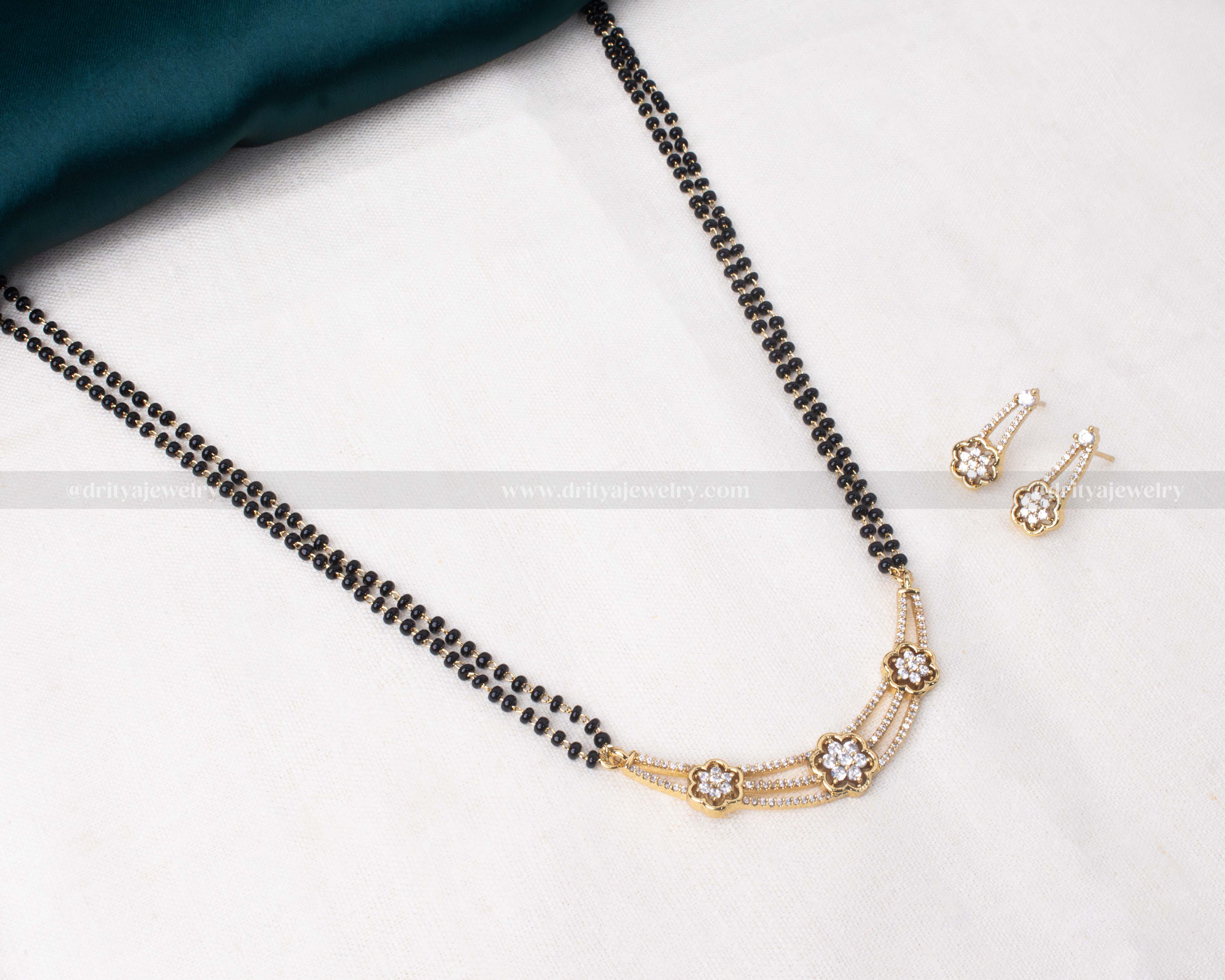 Elegant black beads double-stranded necklace with a floral CZ pendant and matching earrings, perfect for versatile styling.