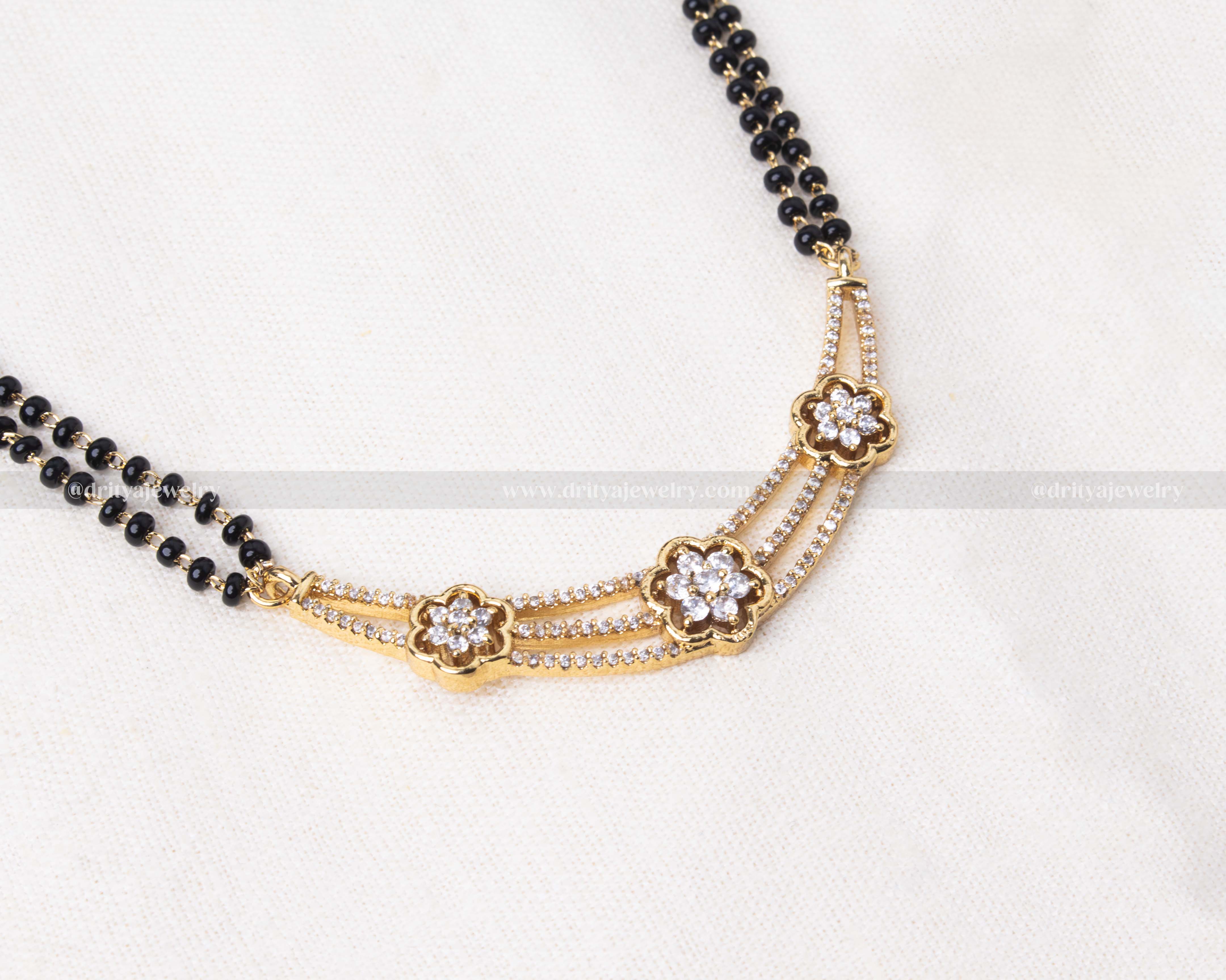 Elegant black beads double-stranded necklace with a floral CZ pendant and matching earrings, perfect for versatile styling.