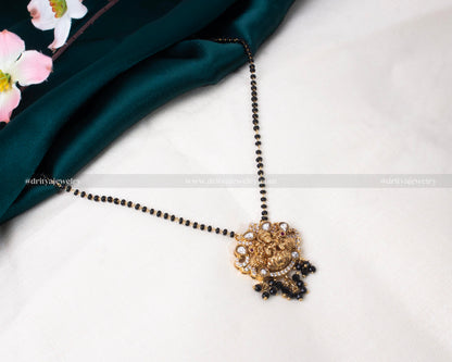 Traditional black beads necklace with gold-plated Lakshmi Devi pendant adorned with Kundan stones, perfect for cultural celebrations and everyday elegance.