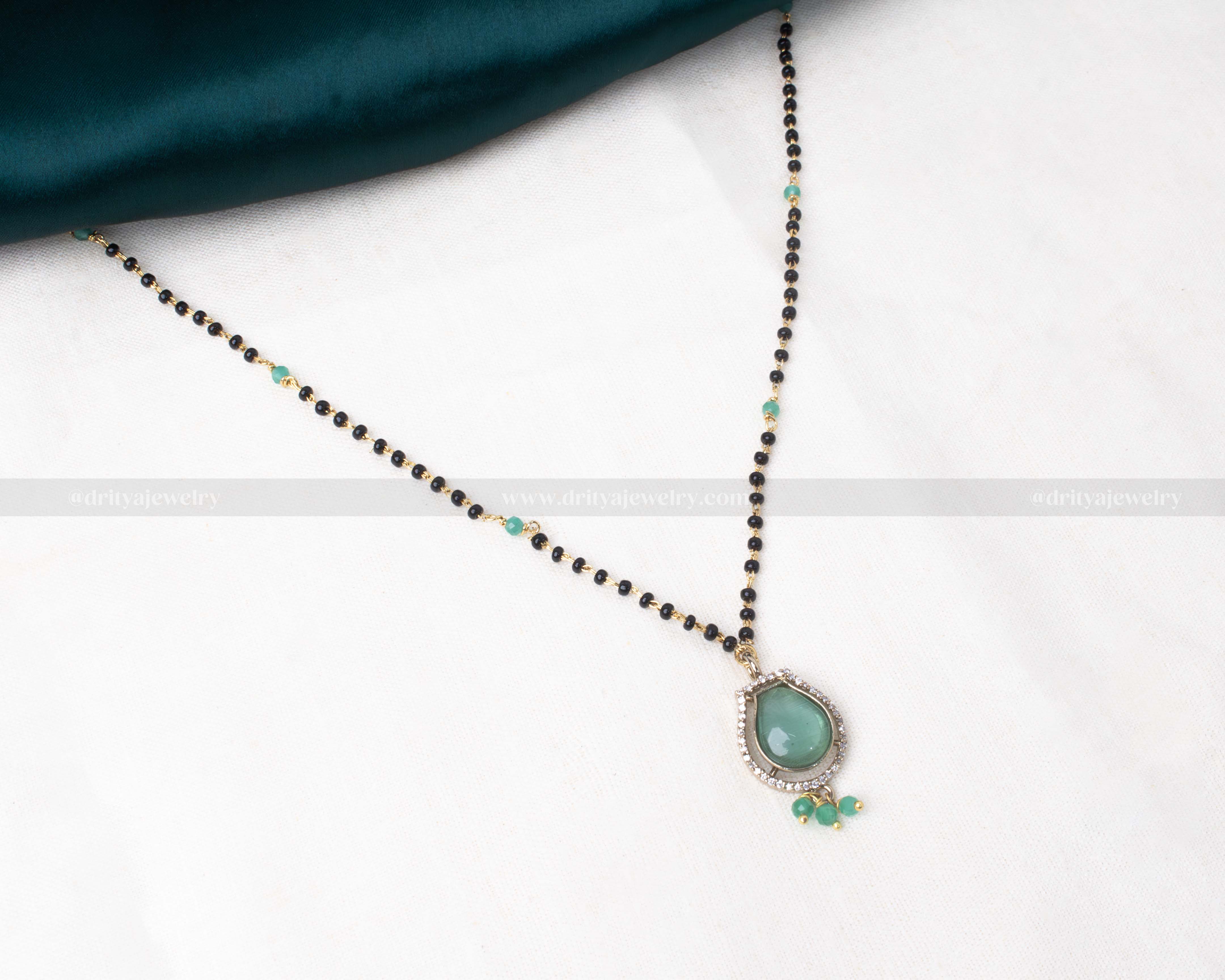 Black beads necklace featuring a Victorian-polished teardrop pendant with green gemstone and CZ accents, ideal for traditional and modern wear.