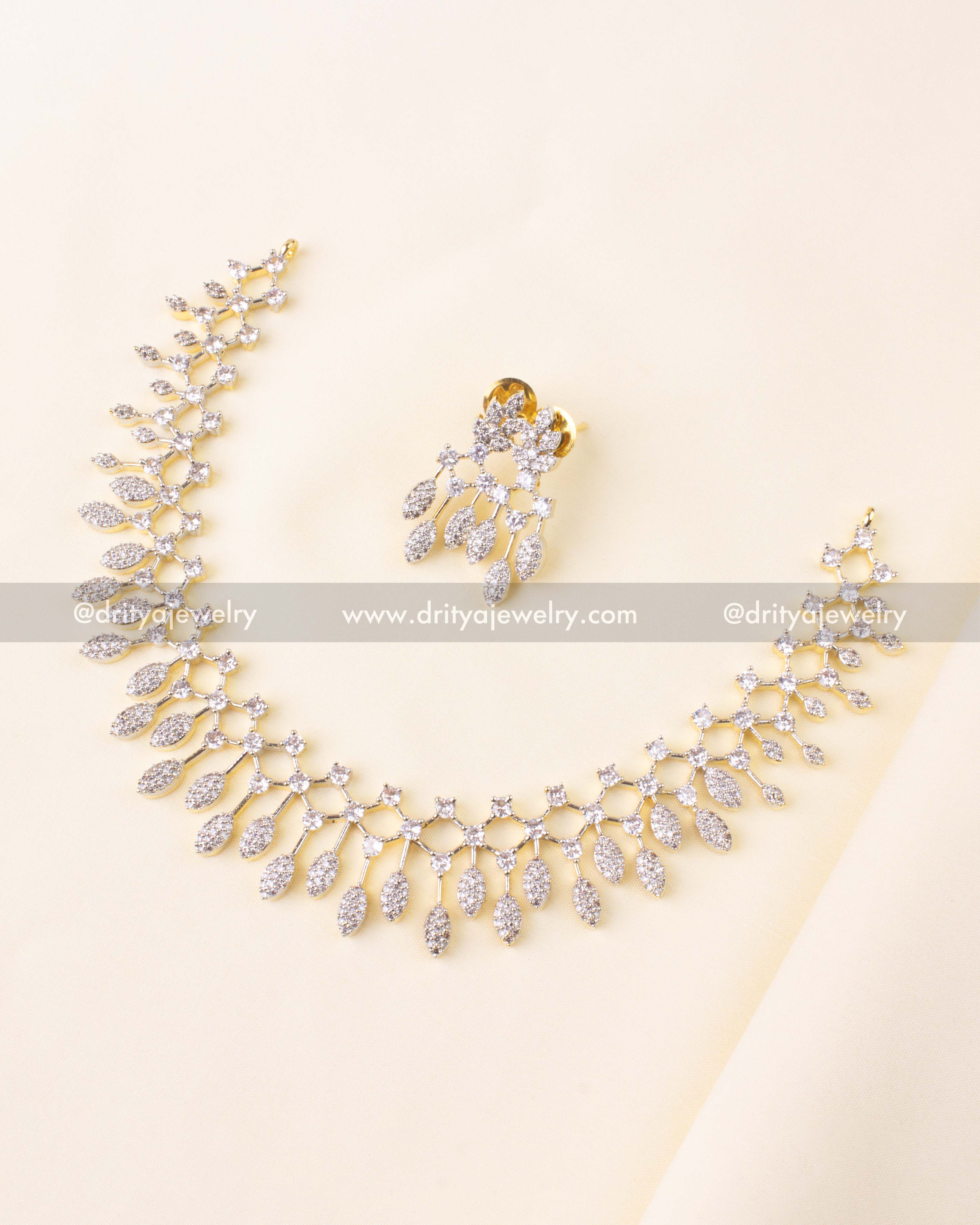 Elegant necklace set with sparkling CZ stones and golden GJ polish, paired with matching drop earrings.