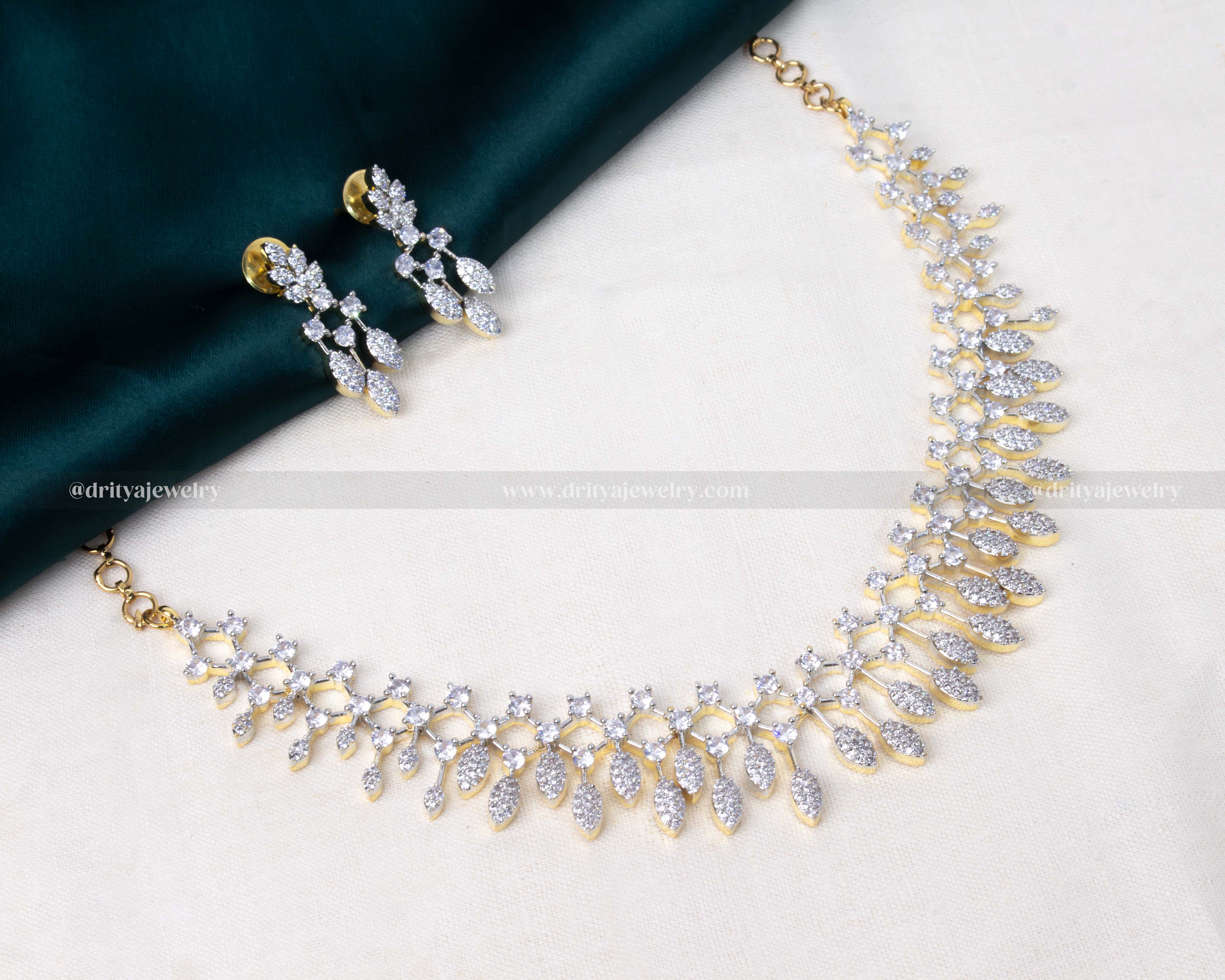 Elegant necklace set with sparkling CZ stones and golden GJ polish, paired with matching drop earrings.