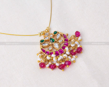 Invisible necklace set with floating gemstones and a Jadua pendant in gold-tone, adorned with magenta and green faux gems and pearls.