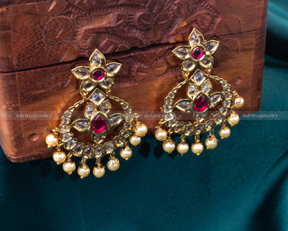 Intricate gold chandbali earrings with ruby, pearl, and kundan embellishments, ideal for weddings and formal events.