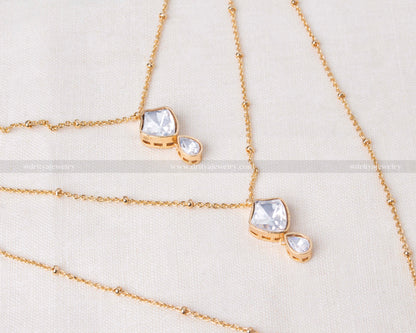 Minimalist necklace featuring premium moissanite stones on an invisible chain with carrot gold polish, paired with matching earrings.