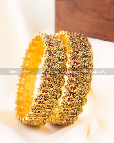 Premium handcrafted ruby red Nakshi bangles shown in a stacked display.
