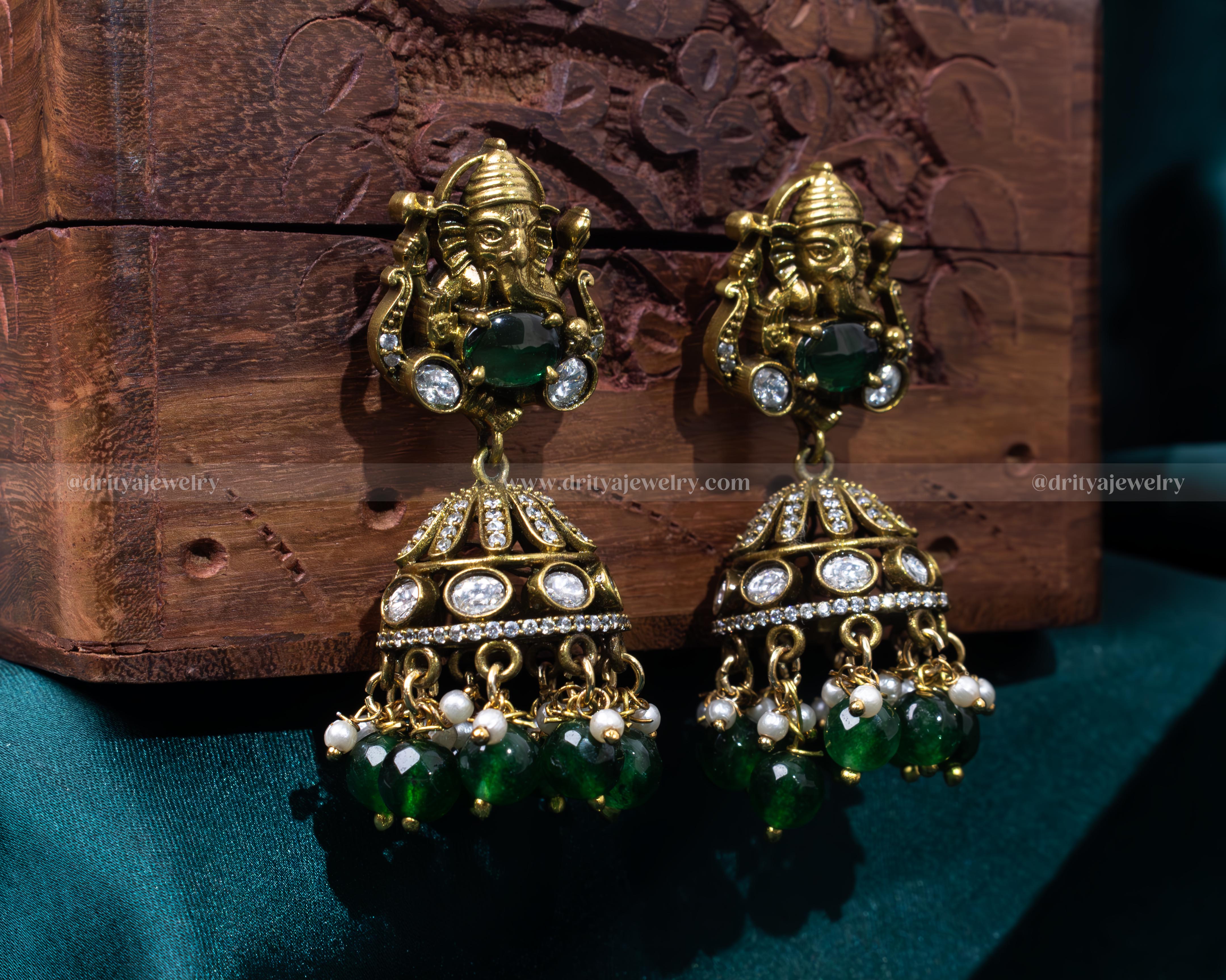 Intricate Victorian jhumka earrings with Lord Ganesh motif and emerald green beads, perfect for spiritual and festive occasions.