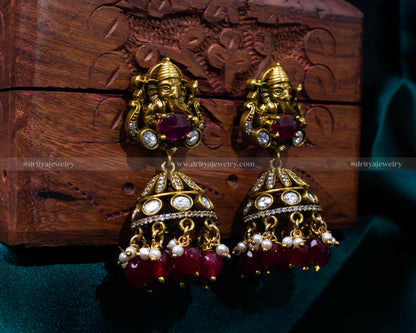 Rich ruby red Victorian jhumka earrings featuring Lord Ganesh, ideal for weddings and cultural celebrations.