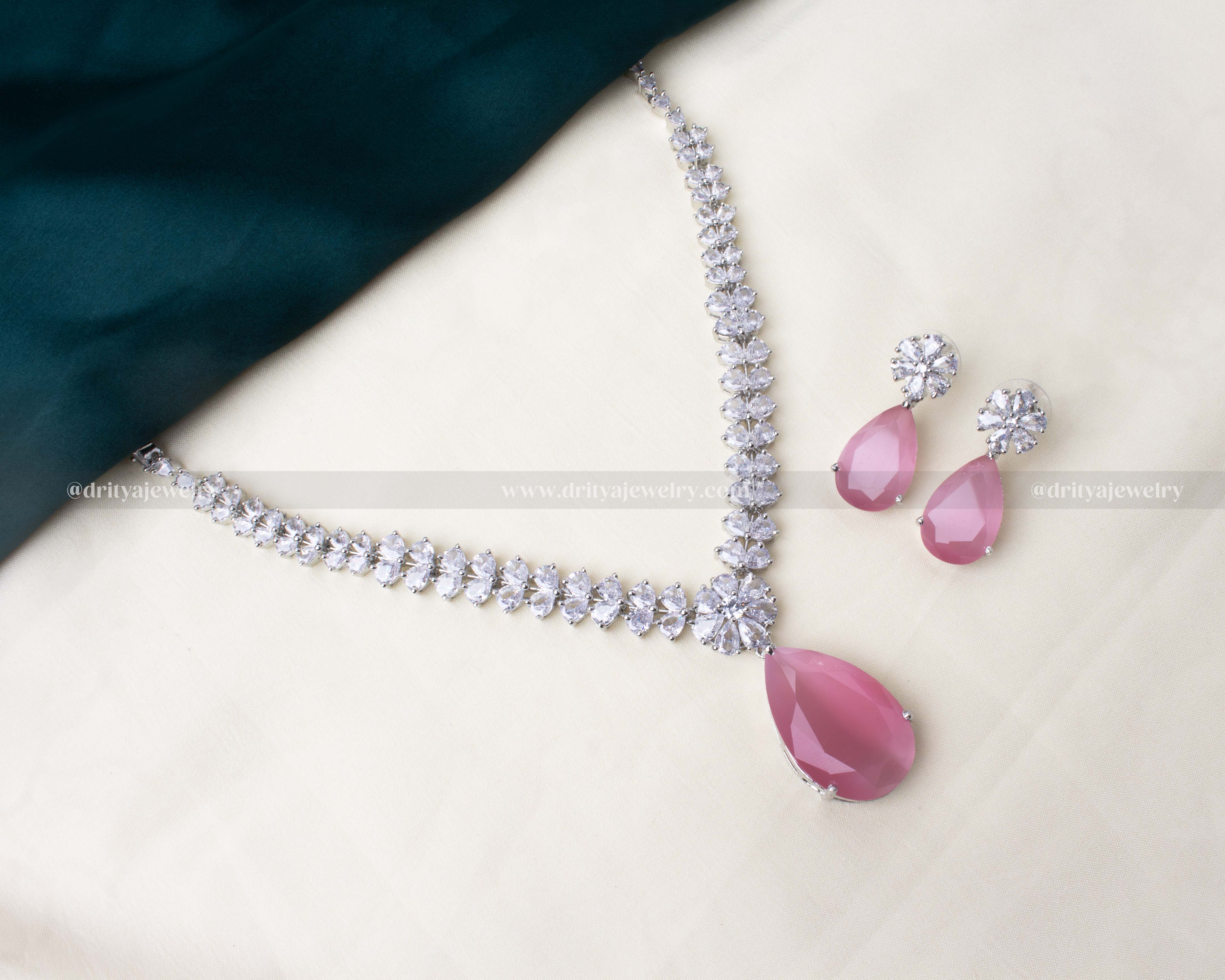 Premium zircon necklace set featuring a blush pink teardrop stone and sparkling AD stones, paired with matching earrings in silver-tone finish.