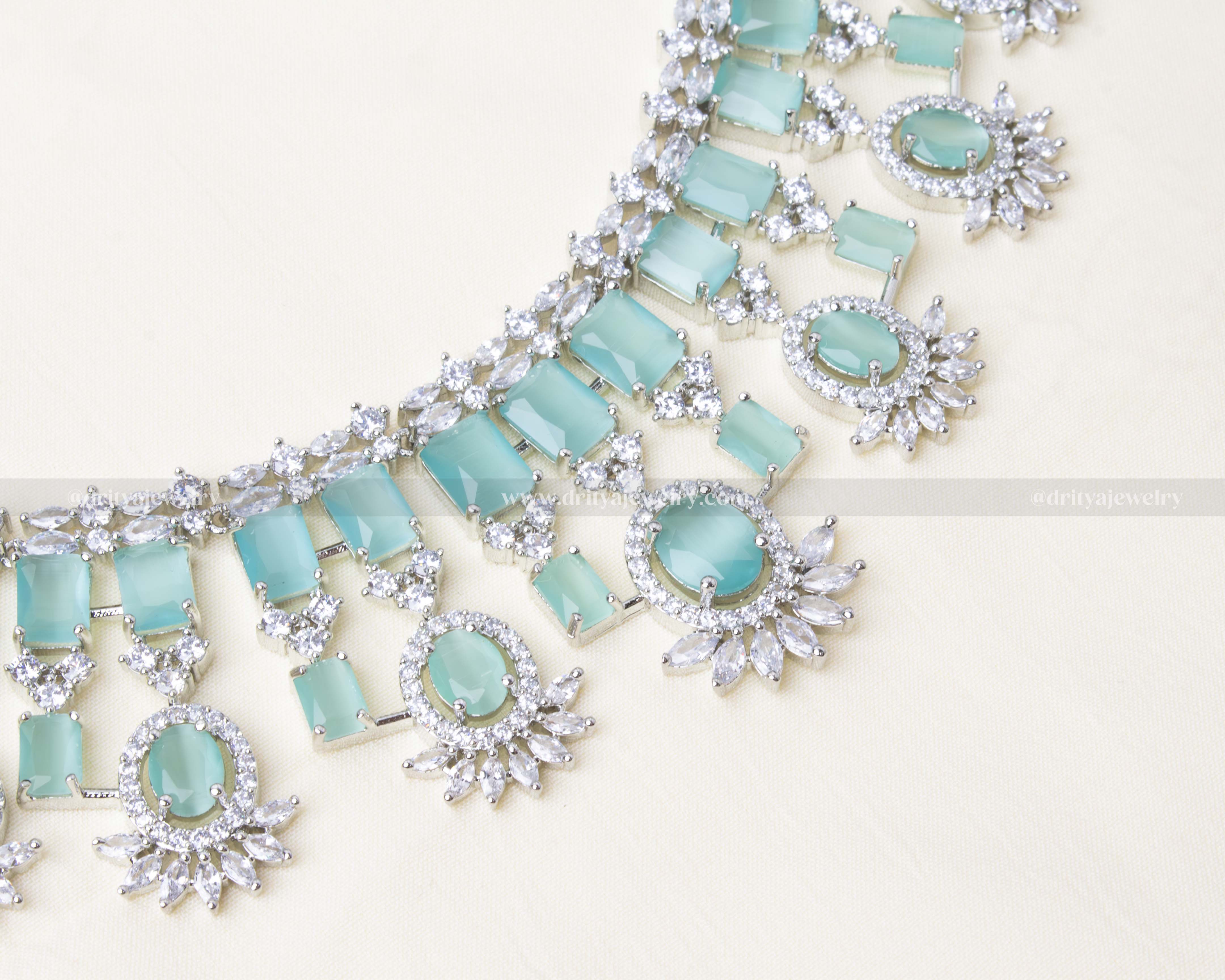 Elegant aqua blue zircon necklace set with matching earrings and a maang tikka, featuring AD stones in a radiant silver finish.