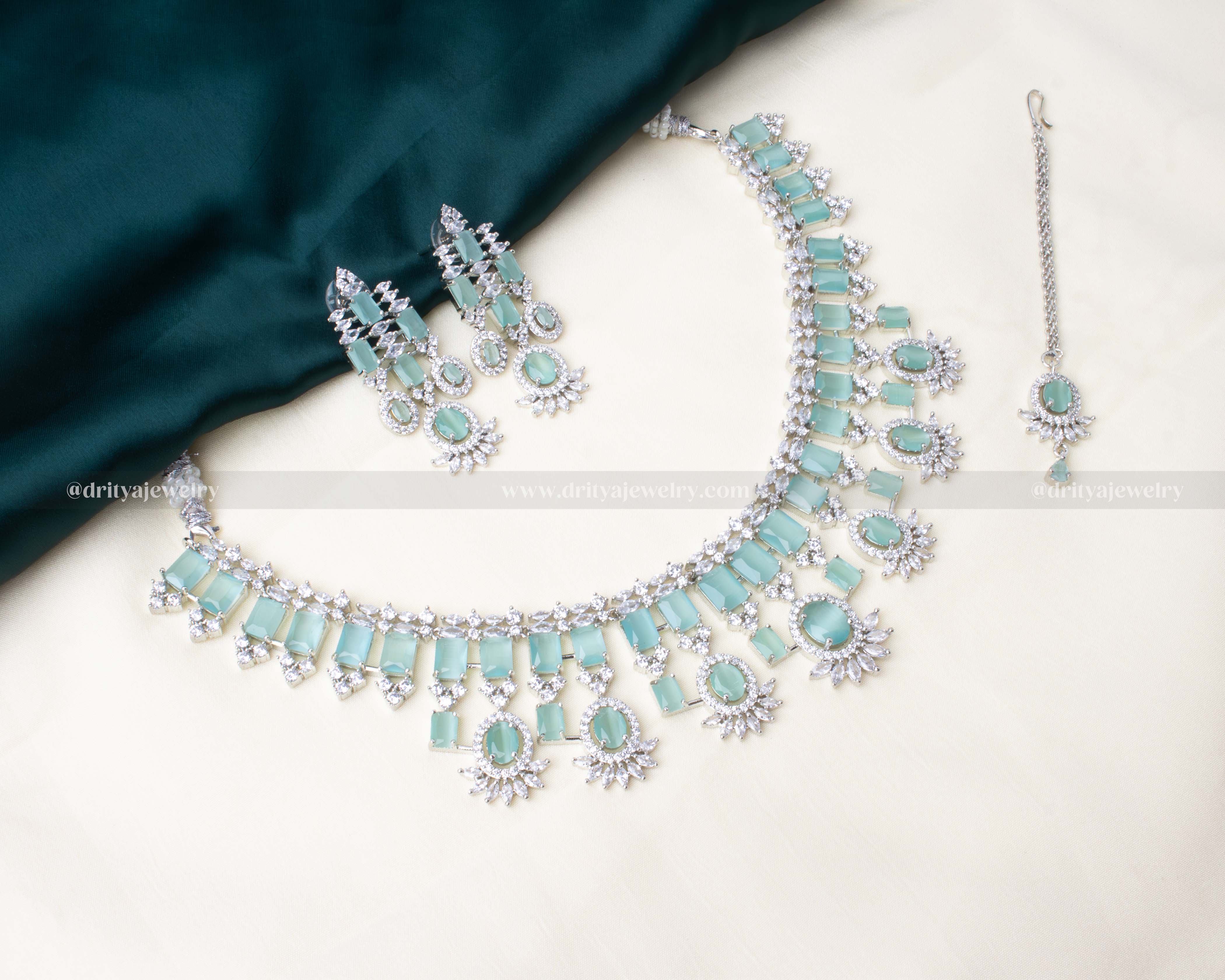 Elegant aqua blue zircon necklace set with matching earrings and a maang tikka, featuring AD stones in a radiant silver finish.