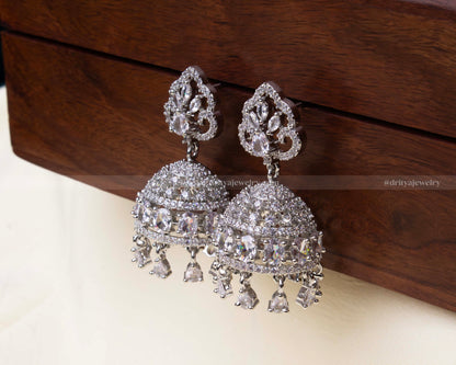 Elegant white zircon Jhumka set with intricate dome design and dangling teardrop embellishments.