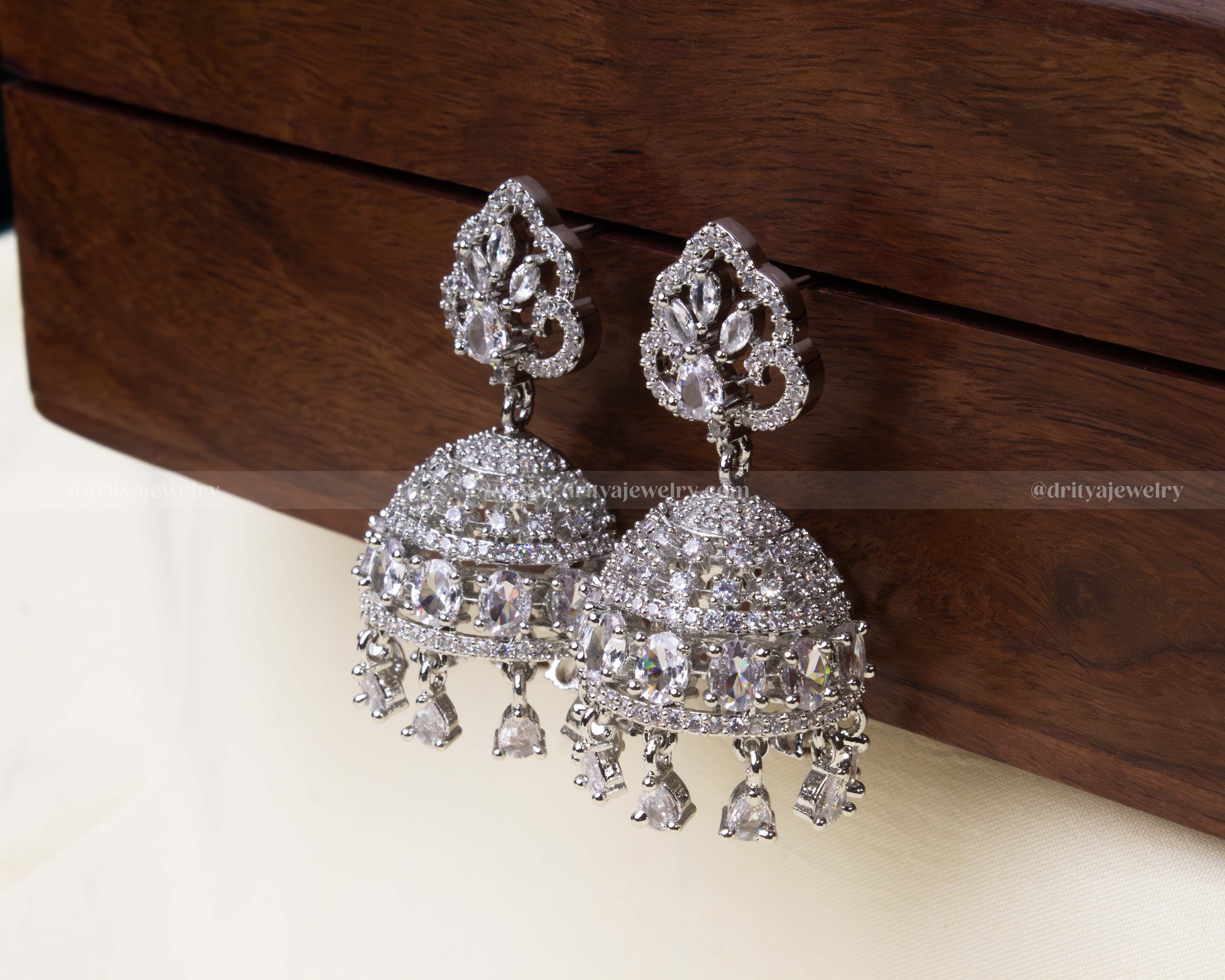 Elegant white zircon Jhumka set with intricate dome design and dangling teardrop embellishments.