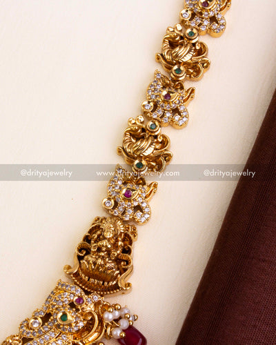 Temple chain design with carved elephants, Lakshmi Devi figures, CZ work, and ruby red stones.