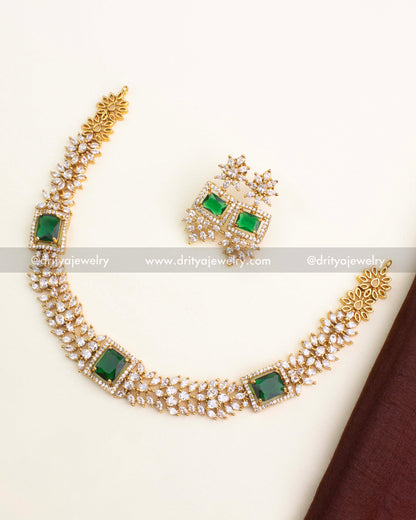 Short necklace set with emerald green square stone and floral CZ chain links, paired with matching earrings.