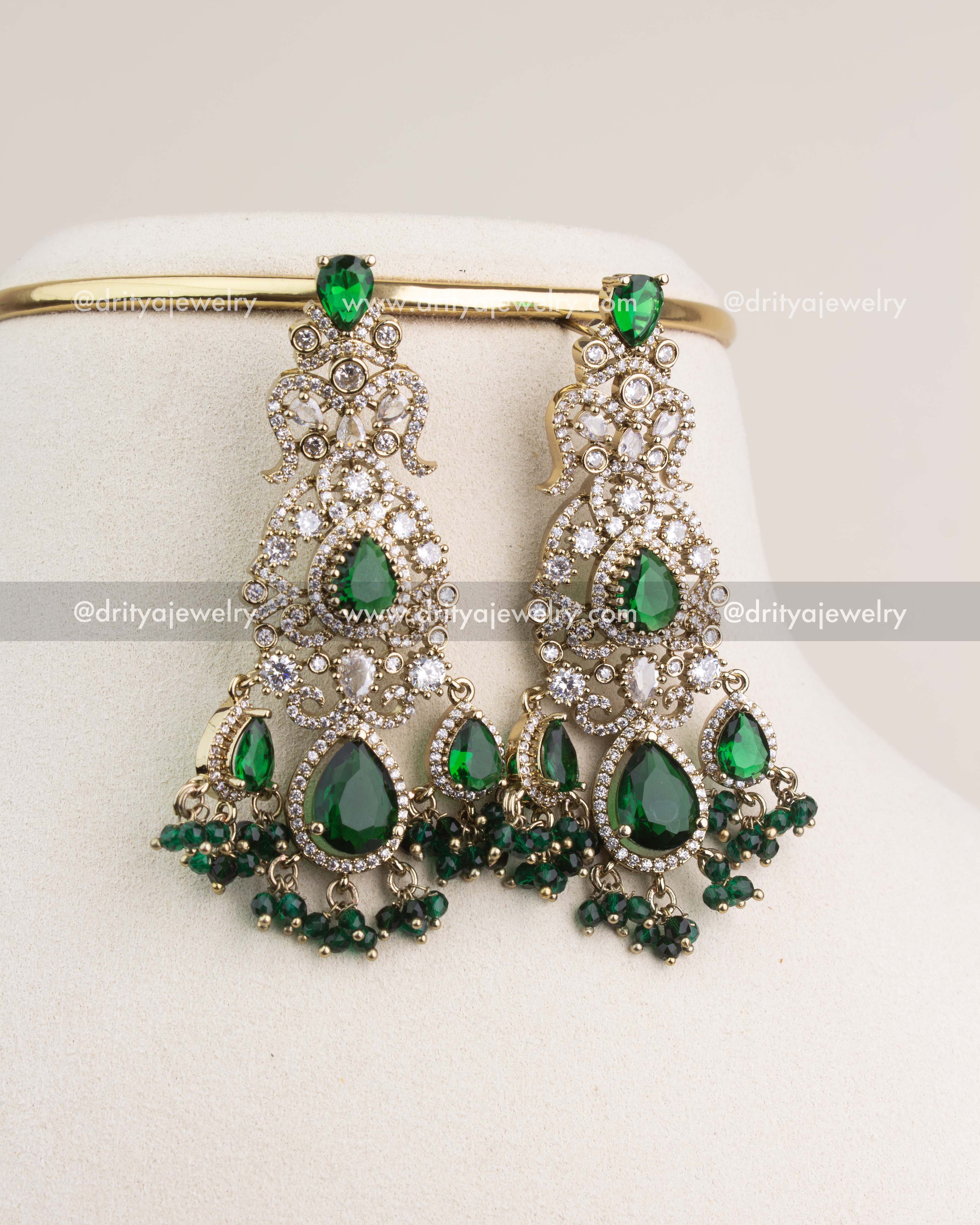 Statement bridal earrings in Victorian finish with emerald green stones and crystal accents.