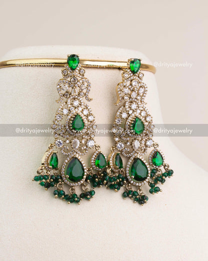 Statement bridal earrings in Victorian finish with emerald green stones and crystal accents.