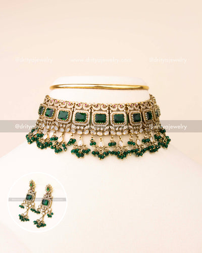 Shop this regal emerald green Kundan choker set, designed with vivid square stones, polki detailing, and elegant bead drops. Includes matching statement earrings for a complete festive look.