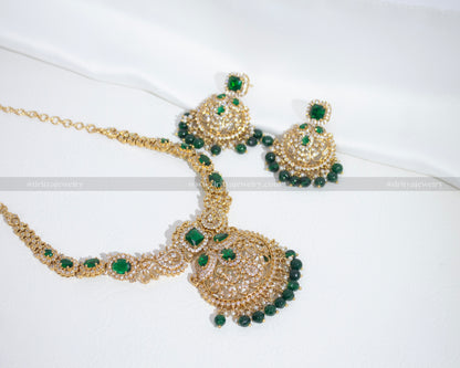 Stunning emerald green Kundan necklace set by Dritya Jewelry with intricate Kundan work and green gemstone embellishments, along with matching earrings.