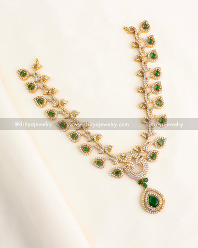 Short necklace featuring emerald green teardrop stones, CZ embellishments, and gold finish.
