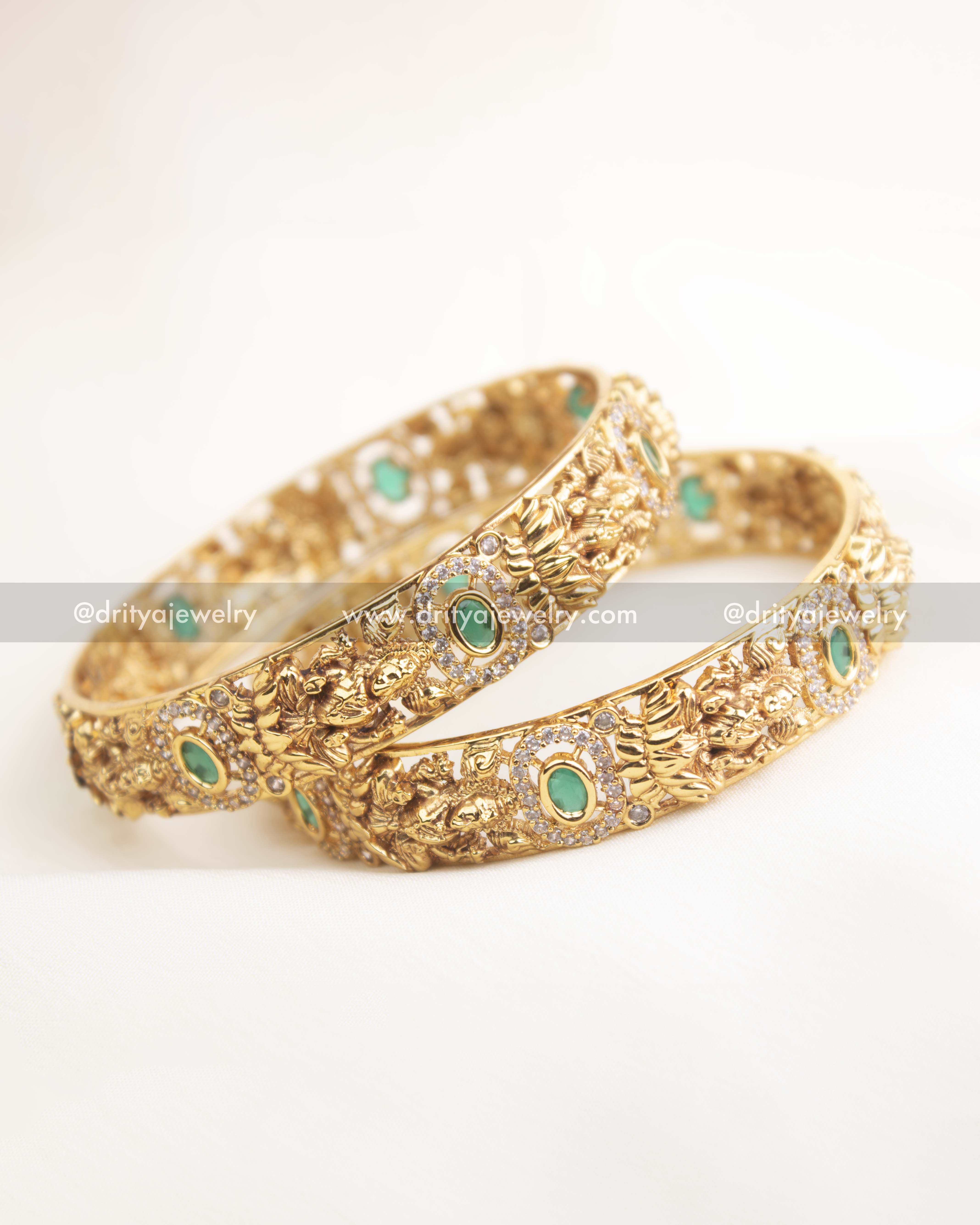 Side profile of premium temple bangles featuring antique gold carving and green gemstone accents