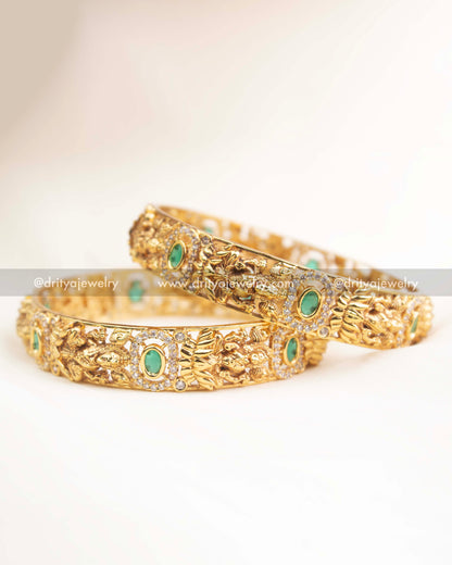 Close-up of goddess motif, AD stone halo, and emerald green centerpiece on temple-style bangles