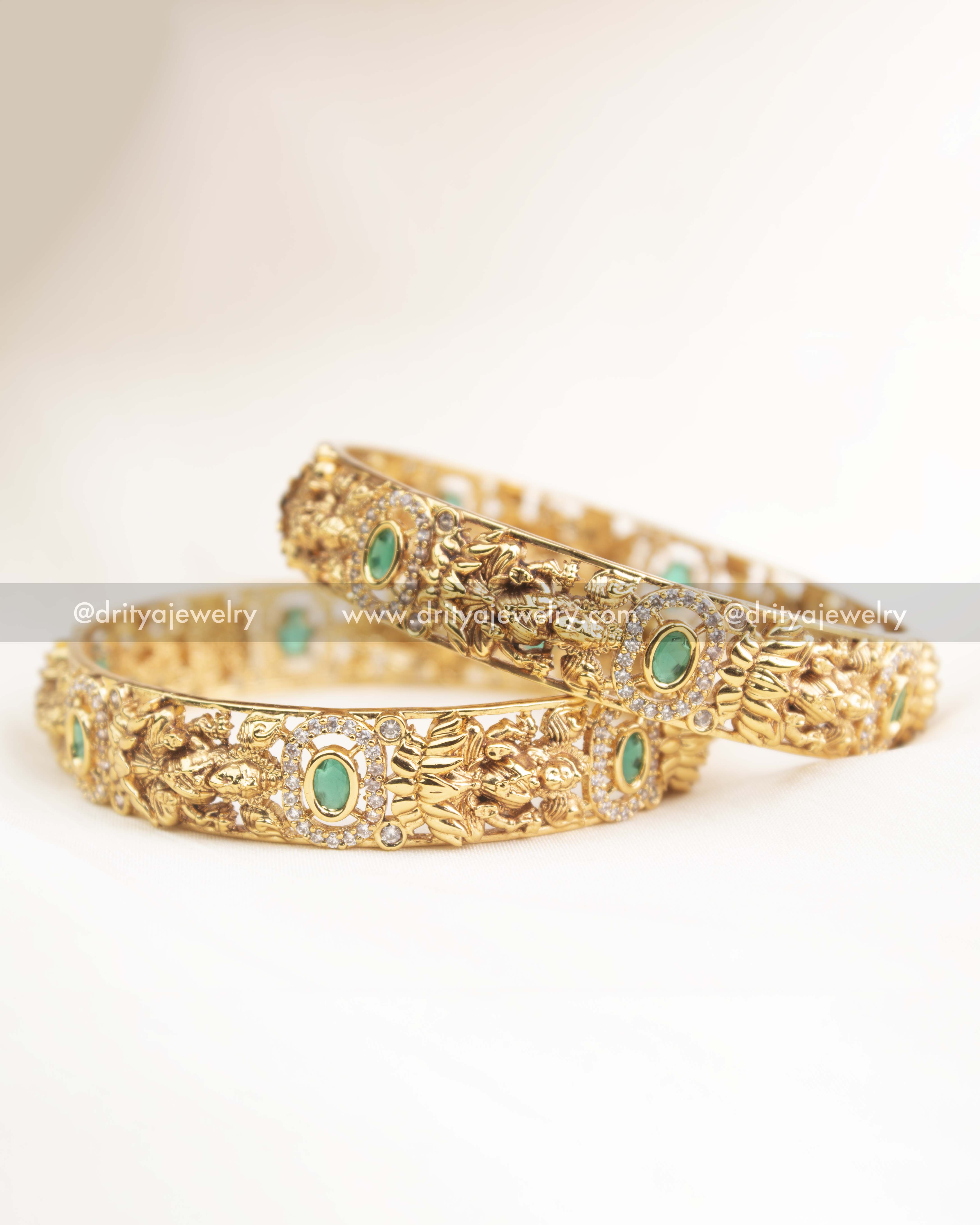 Close-up of goddess motif, AD stone halo, and emerald green centerpiece on temple-style bangles