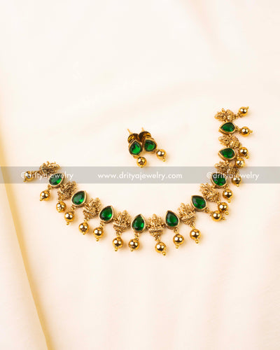 Short necklace set with emerald green stones and antique gold goddess motifs.