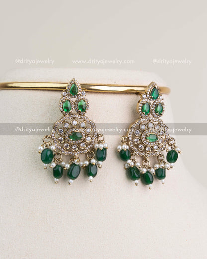 Matching Victorian-style earrings with emerald green stones and mini pearl drops.
