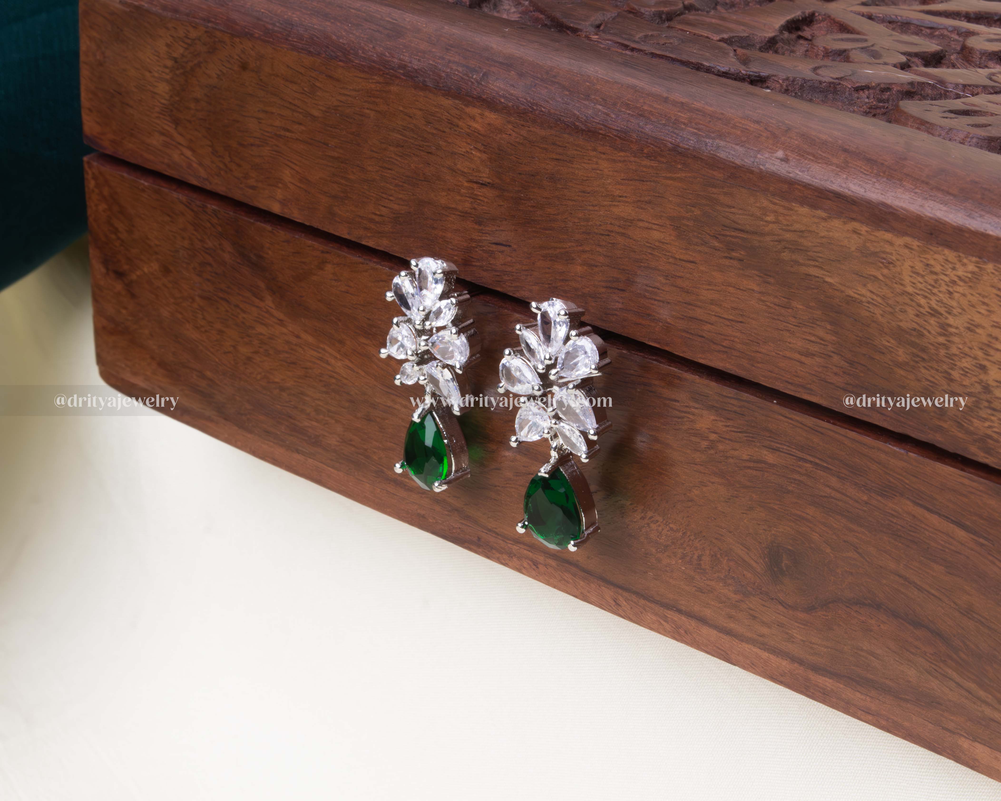 Elegant emerald zircon dangler earrings with white marquise zircon stones and a polished silver-tone finish.