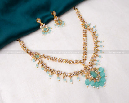 Elegant layered necklace set featuring aqua stones and CZ accents, paired with matching earrings, perfect for special occasions.