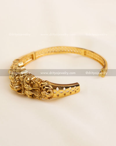 Gold-plated open kada with visible hinge and floral inner lattice detailing.