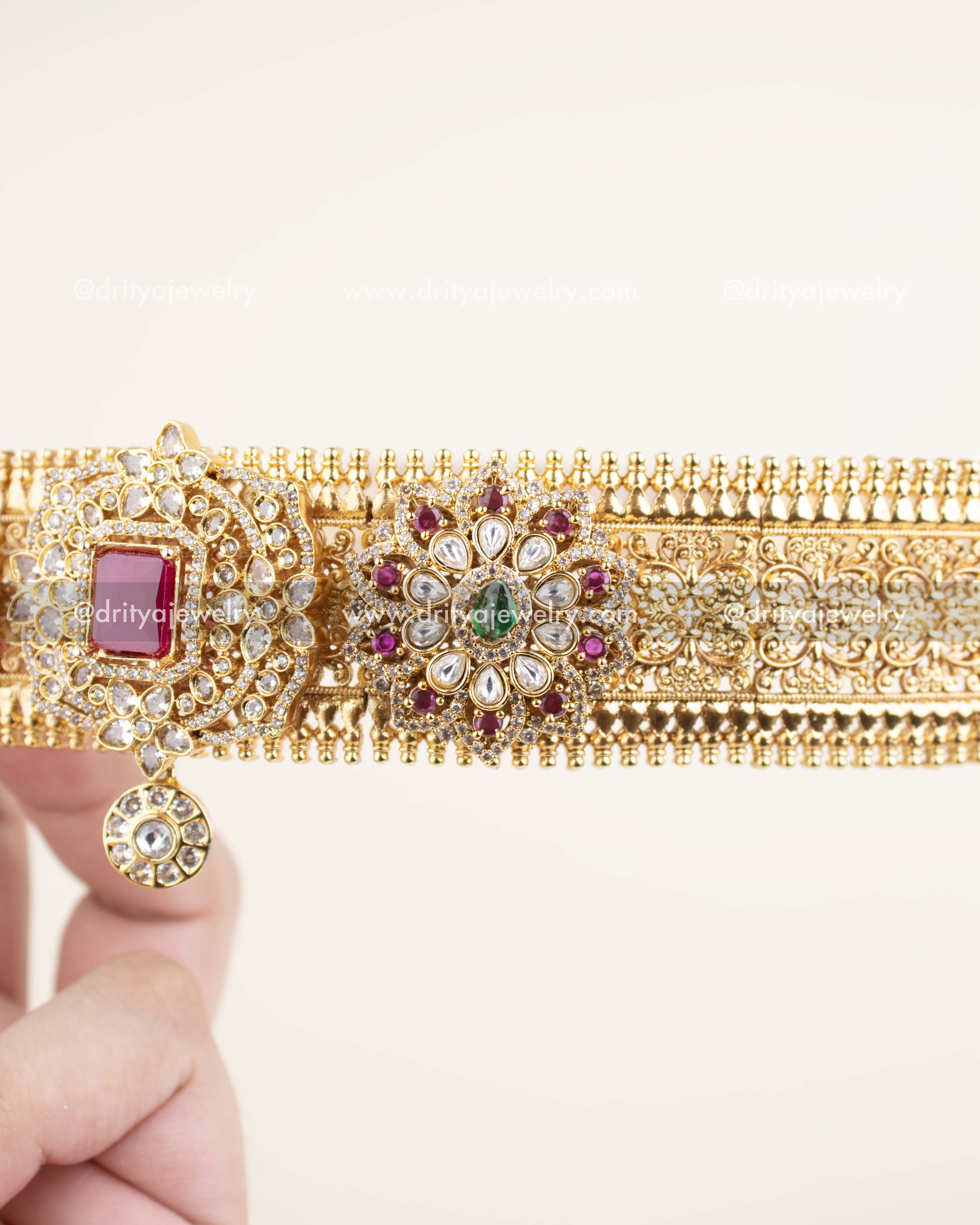 Full frontal view of floral kundan work vaddanam with pink, green, and white stonework.