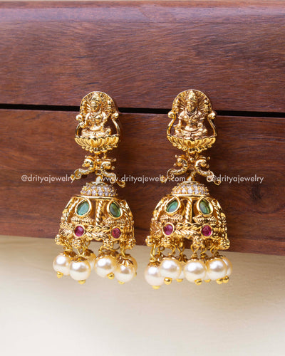 Full front view of small antique temple Jhumka earrings with intricate motifs and classic pearl hangings.