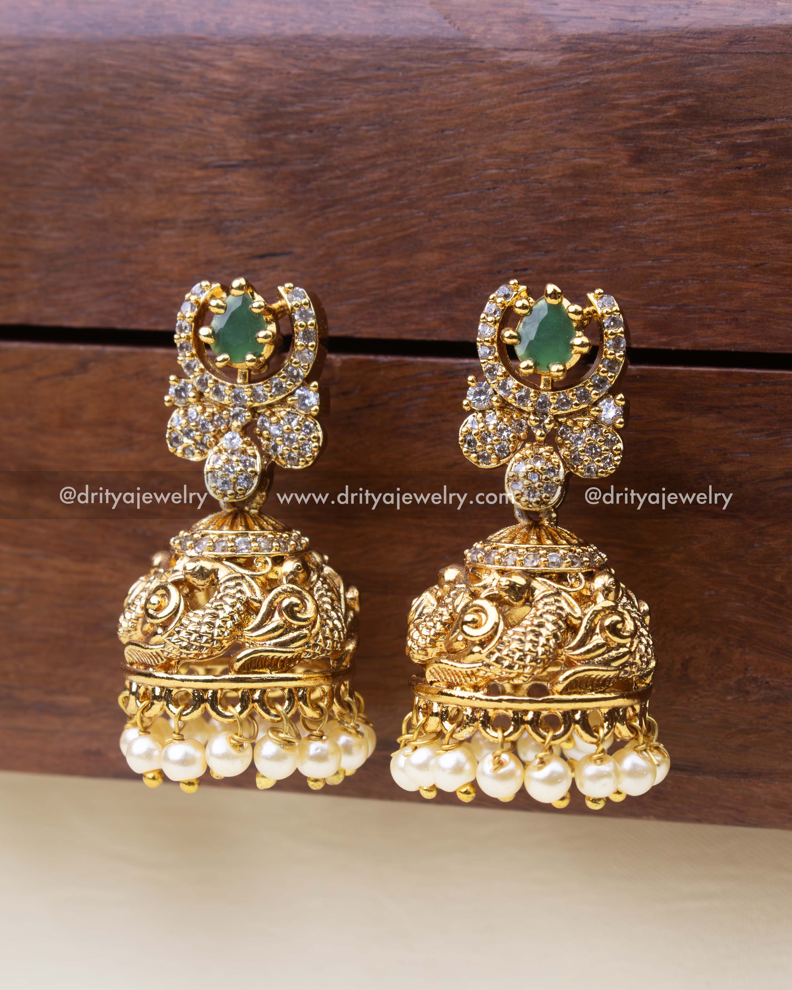 Small temple-style jhumkas with green stone top, CZ detailing, and pearl drops.