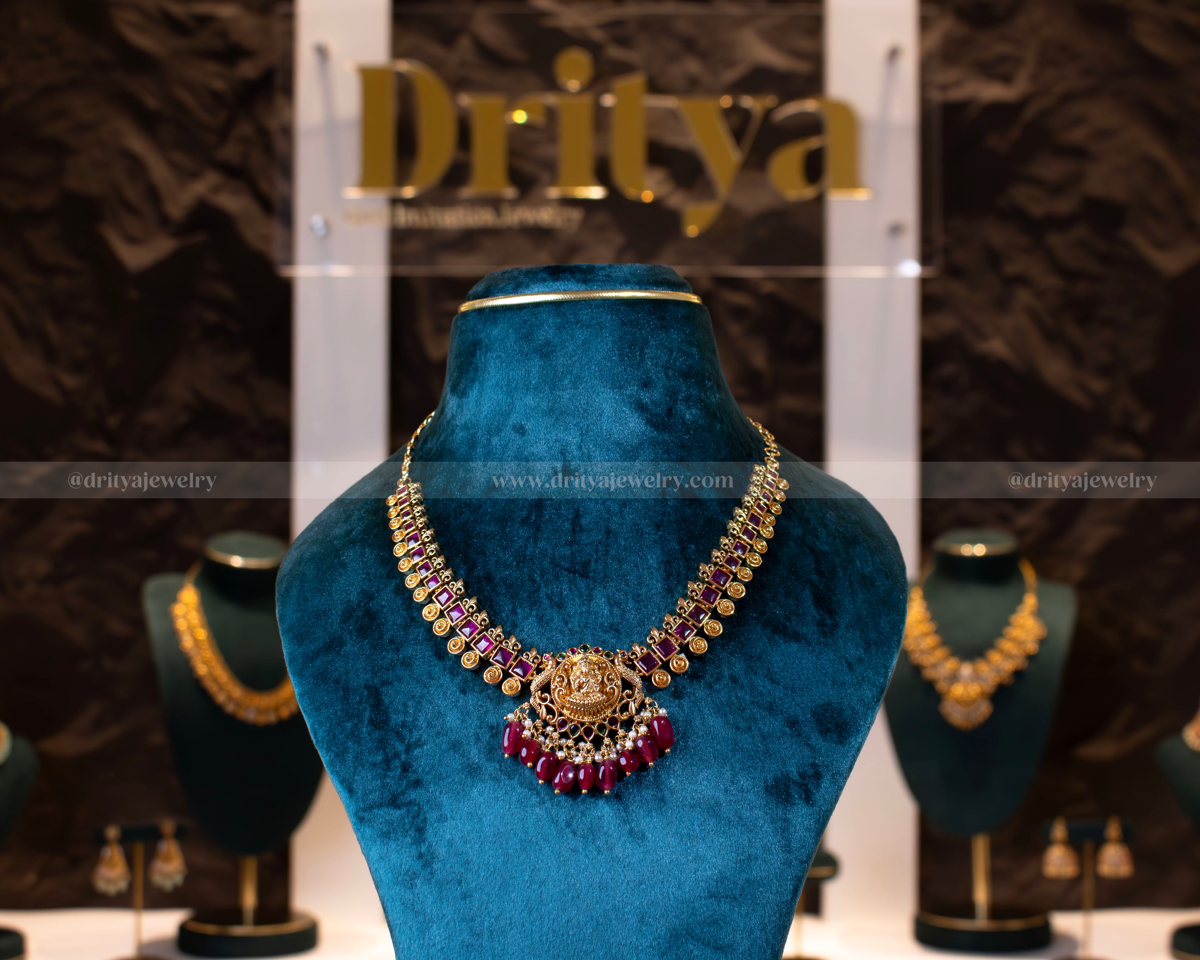 Front view of the temple necklace set from Dritya Jewelry, highlighting the intricate gold-plated design with ruby and pearl detailing.