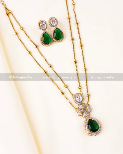 Elegant gold-tone double-layer necklace with emerald green pendant and matching CZ earrings