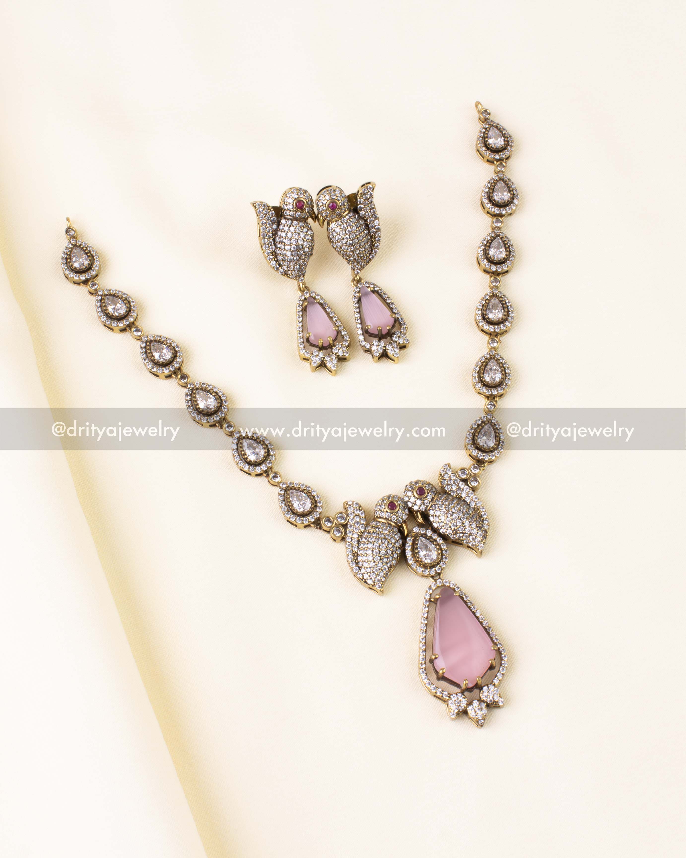 Premium Victorian necklace set featuring pink gemstone drop and parrot motifs, displayed flat.