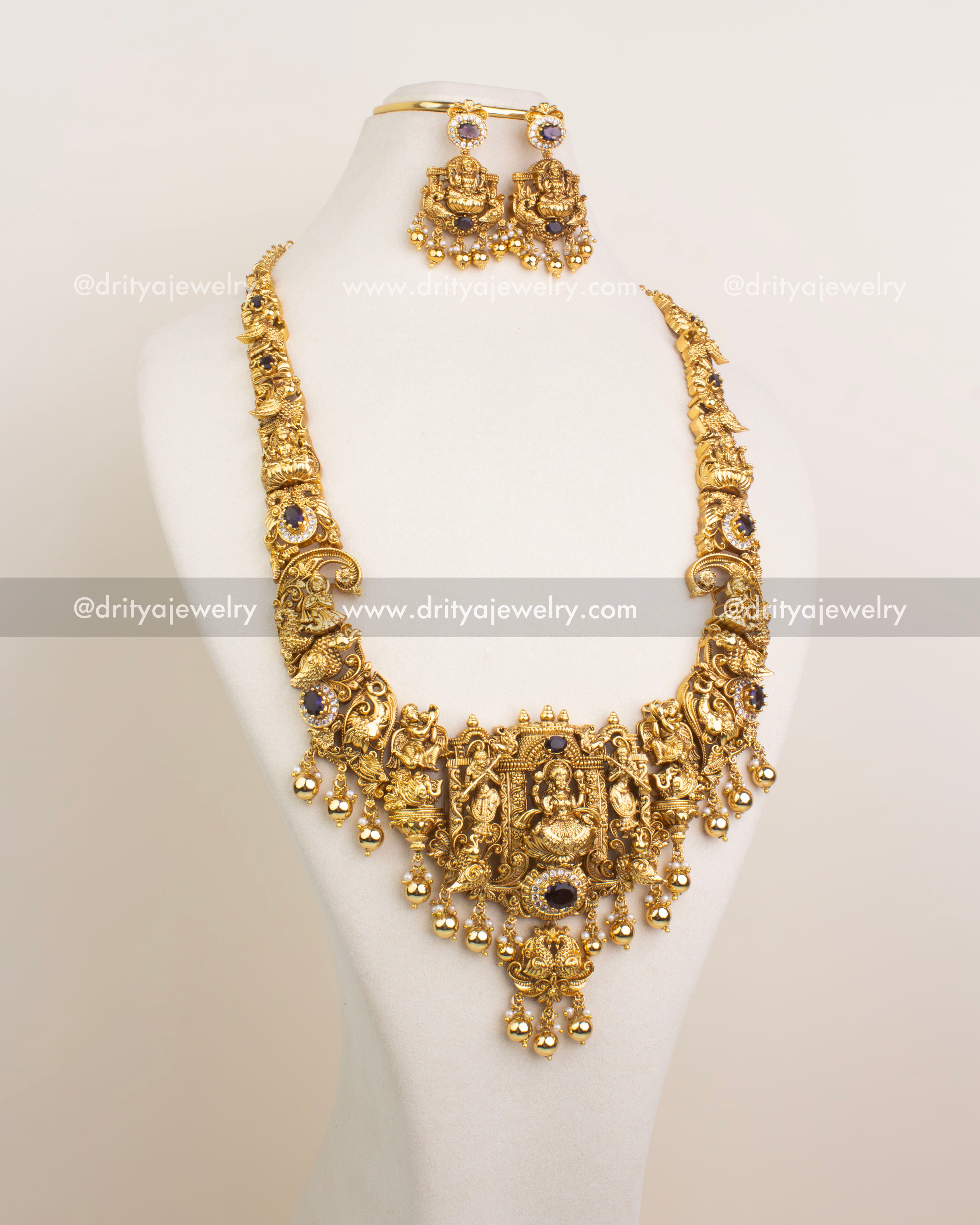 Traditional Nakshi bridal long necklace set with intricate Lakshmi Devi pendant and purple stone detailing, shown with matching earrings on bust display